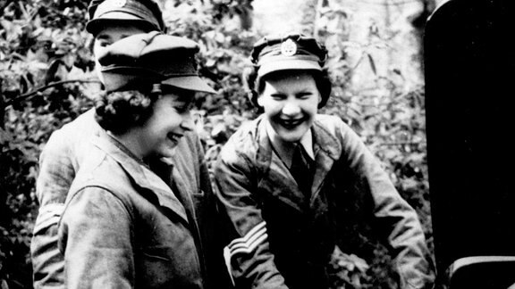 Die 19-jährige Prinzessin Elizabeth (vorn) steht 1945 als Mitglied des weiblichen Freiwilligen-Corps der britischen Armee neben einem Auto und nimmt Instruktionen entgegen.