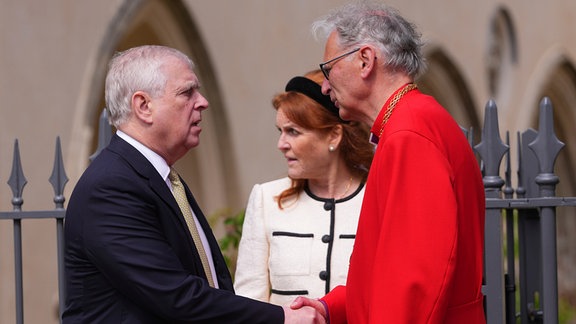Prinz Andrew, Herzog von York, bedankt sich beim Dekan von Windsor, Christopher Cocksworth, nach dem Ostermatine-Gottesdienst in der St. George's Chapel auf Schloss Windsor; hinter ihnen steht Andrews Ex-Ehefrau Sarah Ferguson, genannt Fergie.