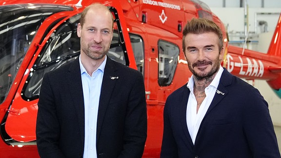 William (l), der Prinz von Wales, posiert mit David Beckham vor einem der neuen Hubschrauber der London Air Ambulance Charity bei einem Besuch der RAF Northolt. 