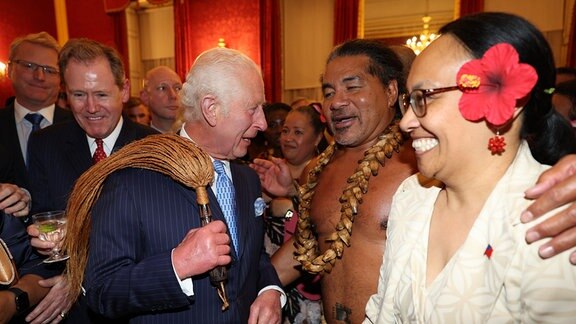 König Charles III. bekommt vom ehemalige samoanischen Rugbyspieler Freddie Tuilagi Tanzbewegungen gezeigt.