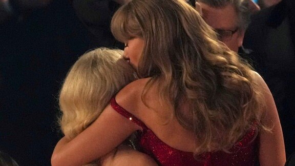 Sabrina Carpenter, links, and Taylor Swift, rechts, umarmen einander.