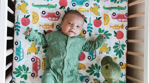 Baby liegt in in Kinderbett