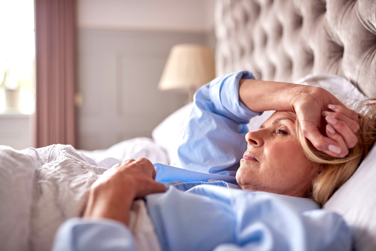 Eine Frau liegt wach in einem Bett