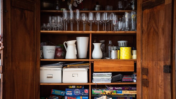 In einem Wohnzimmer steht ein voller Schrank