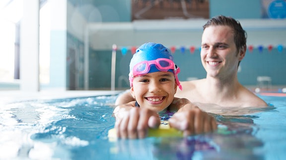 Kind mit Erwachsenem im Schwimmbad