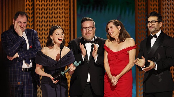 Selena Gomez und weitere Personen nehmen auf einer Bühne einen Preis entgegen