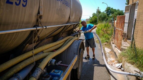  Ein Arbeiter füllt einen Wassertank bei dem Wasserversorgungsunternehmen der Stadt Agrigento, auf, 
