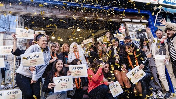 Die Gewinner des ersten Preises der außerordentlichen spanischen Weihnachtslotterie 2023 mit der Nummer 88008 feiern ihr Glück in der Verwaltung Dona Manolita.