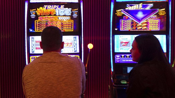 Menschen spielen an einem Spielautomat