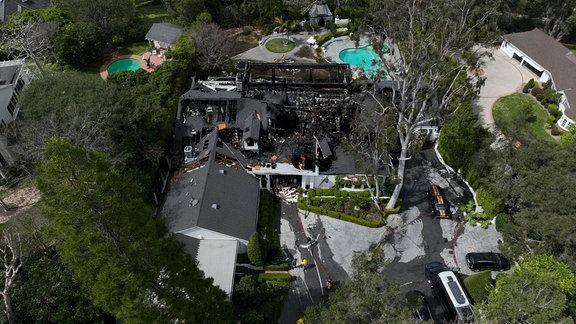 Eine Luftaufnahme zeigt ein durch Feuer beschädigtes Haus, das dem Model Cara Delevingne zu gehören scheint.