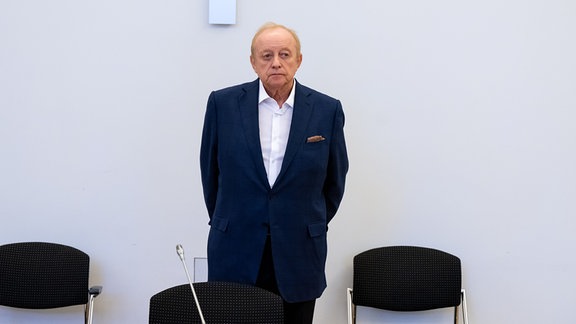 Alfons Schuhbeck, Koch und Unternehmer, steht vor Prozessbeginn als Angeklagter im Gerichtssaal.
