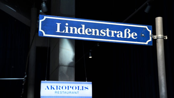 Straßenschild und Restaurantschild 2020 in der Ausstellung "Lindenstrasse" im Haus der Geschichte