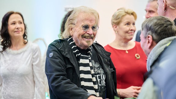 Frank Zander (M) und Franziska Giffey (r, SPD), Berlins Wirtschaftssenatorin, begrüßen ankommende Gäste bei der 30. Weihnachtsfeier für Obdachlose von Frank Zander im Hotel Estrel.