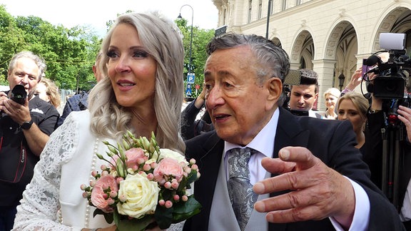 Richard Lugner und Simone (Bienchen) Reiländer, während ihrer Hochzeit in Wien, 2024, umringt von Fotografen