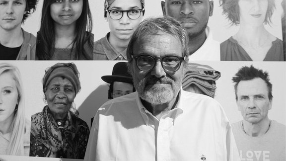 Portrait von Fotograf Oliviero Toscani vor eine Fotocollage seiner Portraits