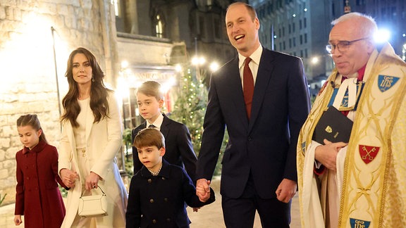 Prinz William und Kate Middleton und ihre Kinder Prinz George, Prinzessin Charlotte und Prinz Louis gehen nach dem Weihnachtsliedgottesdienst in der Westminster Abbey in London auf der Straße.
