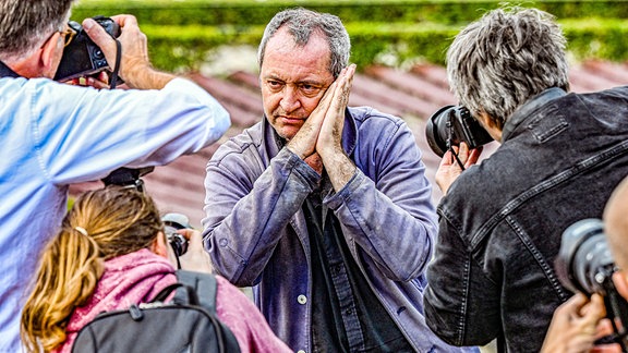 Rainald Grebe, von Fotografen umlagert, auf der Waldbuehne in Berlin.