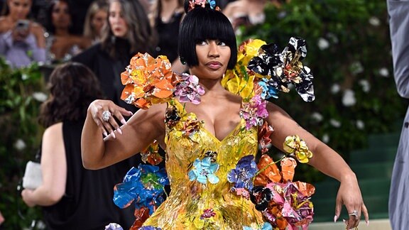 Nicki Minaj in einem güldenen Kleidchen mit vielen farbenfrohen Blüten besetzt.