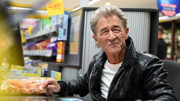 Der deutsche Rockmusiker Peter Maffay arbeitet an der Kasse eines Netto-Supermarktes. 