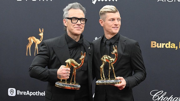Robbie Williams steht neben Toni Kroos