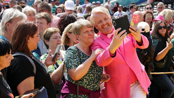 Fernsehmoderator, Musicaldarsteller, Musiker und Entertainer Ross Antony macht ein Selfie mit einer Frau aus einem Publikum