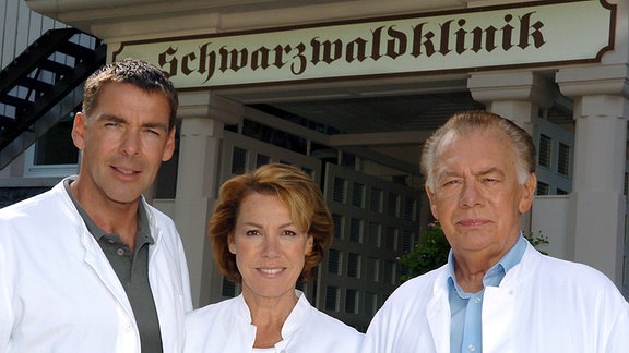 Anlässlich von Dreharbeiten für eine Jubiläumssendung der Fernsehserie "Die Schwarzwaldklinik" posieren am Montag (16.08.2004) vor der "Schwarzwaldklinik" im Glottertal (Kreis Breisgau-Hochschwarzwald) die Schauspieler (v.l.): Sascha Hehn (Dr. Udo Brinkmann) , Gaby Dohm (Frau Dr. Brinkmann) und Klausjürgen Wussow (Prof. Dr. Klaus Brinkmann).