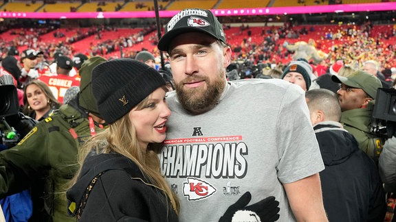 Kansas City Chiefs Tight End Travis Kelce und seine Freundin, die Entertainerin Taylor Swift, stehen nach dem 32:29-Sieg der Chiefs gegen die Buffalo Bills im AFC Championship Game im Arrowhead Stadium in Kansas City auf dem Spielfeld.