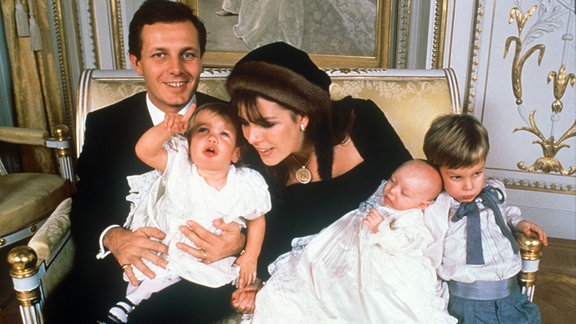 Prinzessin Caroline von Monaco sitzt mit ihrem damaligen Ehemann Stefano Casiraghi und den gemeinsamen Kindern (l-r) Charlotte Marie Pomeline, Täufling Pierre und Andrea Albert auf einem Sofa.