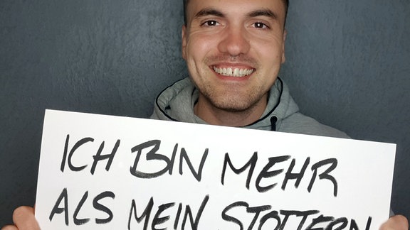 Ein Mann hält ein Plakat in der Hand