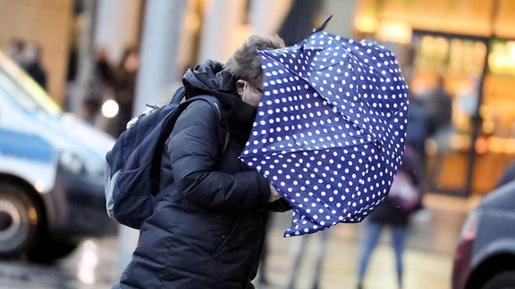Frau mit Regenschirm im Sturm