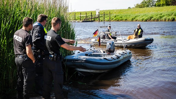 Einsatzkräfte der Polizei fahren bei der Suche nach dem vermissten Arian mit Spürhunden auf Schlauchbooten über die Oste