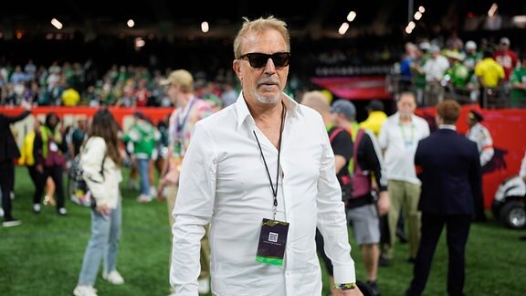 Kevin Costner auf einem Football Feld