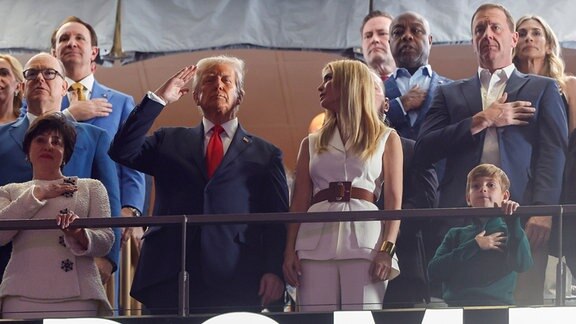US-Präsident Donald Trump und seine Tochter Ivanka sowie Prinz Albert von Monaco stehen inmitten anderer Gäste auf einer Tribüne.
