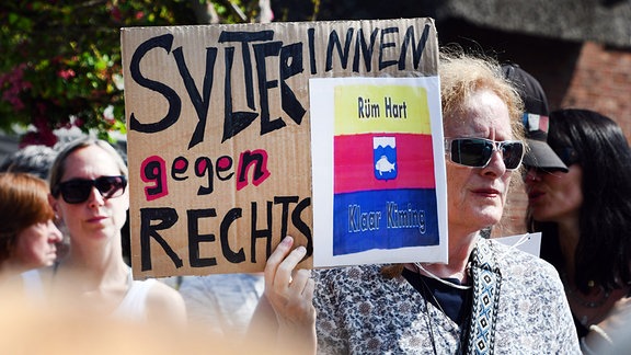 „SylterInnen gegen Rechts“ steht auf einem Schild, dass eine Frau bei einer Mahnwache in der Hand hielt.