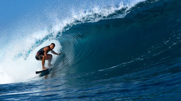 Ein Surfer in einer blauen Welle