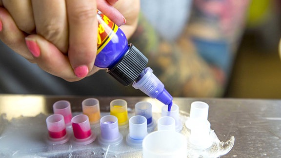 Tattoo Studio - Tätowierfarben werden in kleine Behälter gefüllt