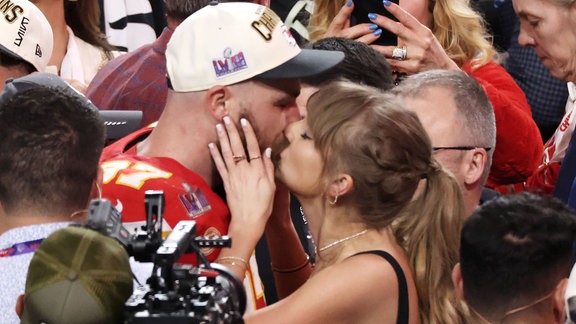 Kansas City Chiefs Tight End Travis Kelce küsst seine Freundin Taylor Swift.