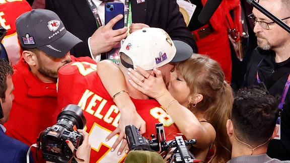 Kansas City Chiefs Tight End Travis Kelce 87 küsst Taylor Swift beim Super Bowl.