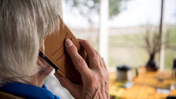 Eine Seniorin telefoniert mit ihrem Smartphone.