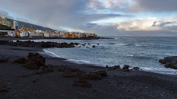 Blick auf den Sonnenuntergang zum Kap Punta Brava vom berühmten Strand Playa Jardin mit schwarzem Sand in Puerto de la Cruz, Teneriffa, Spanien