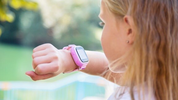 Moderne Technologie für Kinder. Schulmädchen mit ihrer GPS-Smartwatch.