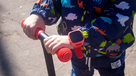 Ein Roller fahrendes Kind mit Smart watch