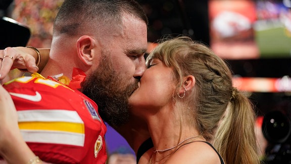 Taylor Swift küsst Travis Kelce.