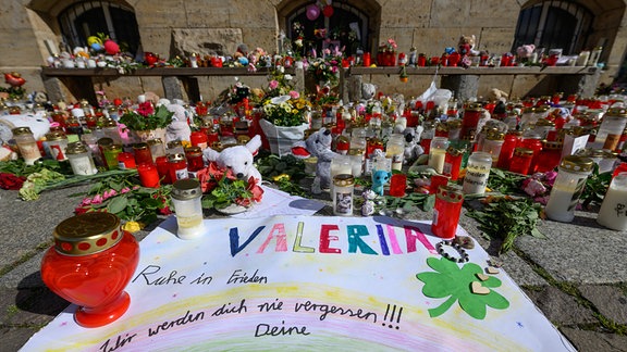 Blumen und Kerzen sind vor einem einem Gottesdienst für die getötete Valeriia auf dem Obermarkt abgelegt