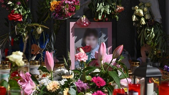 Blumen und Kerzen und ein Foto der getöteten Valeriia aus Döbeln sind vor einem einem Gottesdienst auf dem Obermarkt zu sehen. 
