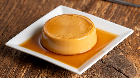 Französischer Flan (ein Dessert) auf dunklem Holz
