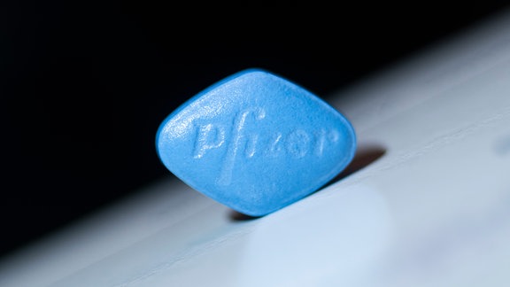 Eine blaue Viagra-Tablette vor dunklem Hintergrund