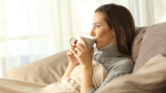 Eine Frau trinkt aus einer Tasse