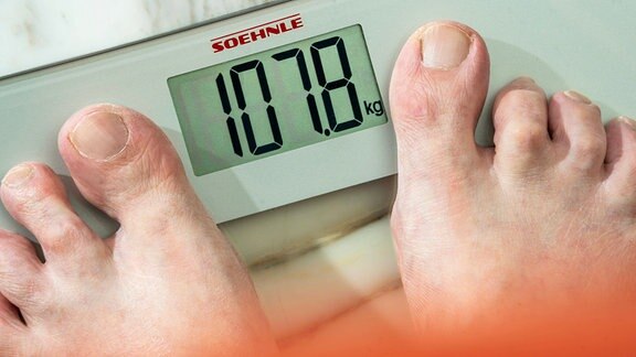 Ein Mann steht auf einer Waage, sie zeigt 107 Kilo. 