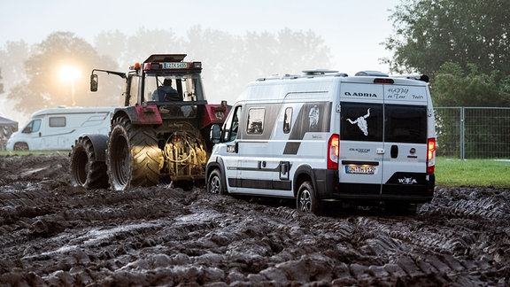 Ein Fahrzeug wird mit Hilfe eines Traktors auf das Gelände des Heavy-Metal-Festivals in Wacken durch den Schlamm gezogen. Das WOA gilt als gröÃtes Heavy-Metal-Festival der Welt.